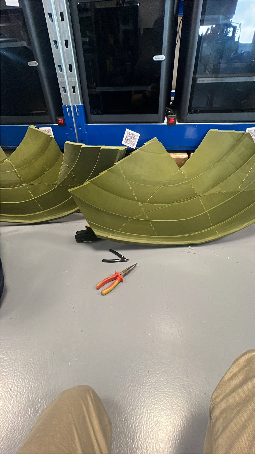 Zwei gebogene Dachabschnitte mit sichtbaren Verbindungen auf dem Werkstattboden
