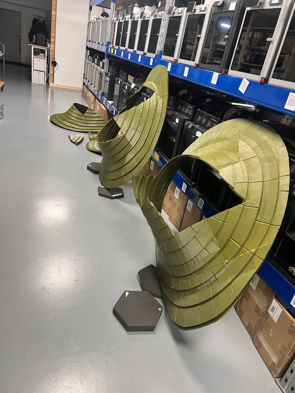 Mehrere große Dachbaugruppen aufgestellt vor einer Reihe von 3D-Druckern